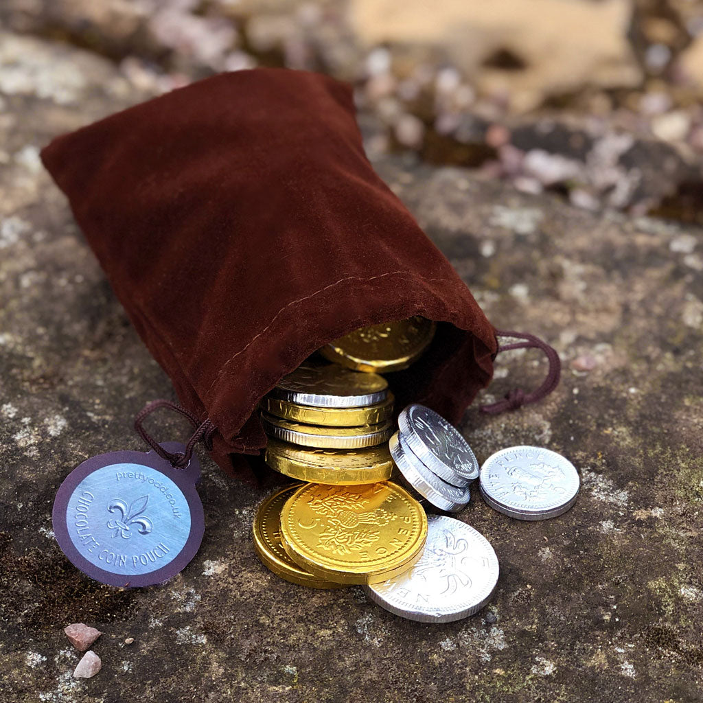 A pouch of loot fit for an adventure!   150g of white chocolate (silver) and milk chocolate (gold) coins fill this velvet drawstring bag - perfect for the swashbuckler or heroic outlaw in your life! Who doesn't love chocolate coins? Now you can take them with you - just make sure you leave enough to pay any tolls or taverns along your way! 