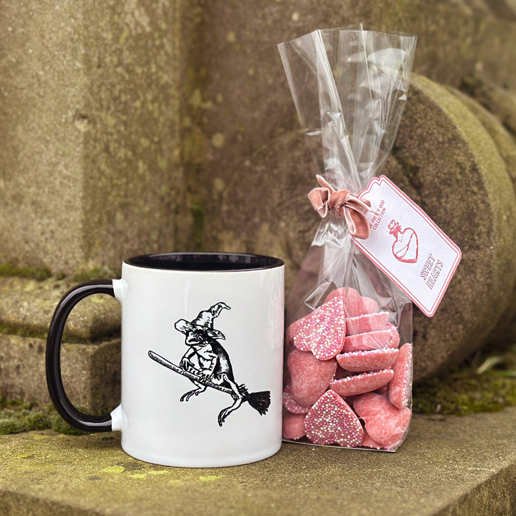 Our magical mascot Winnie the Wiz has her very own mug! Stir up your own personal potion with our 'Witch's Brew' mug gift set, perfect for warming up with this season! This gift set contains our 'Winnie ceramic mug' (11oz/330ml) and a bag of 'Sweet Hearts' (100g) - conjuring up the perfect treat to gift to your witch or warlock!